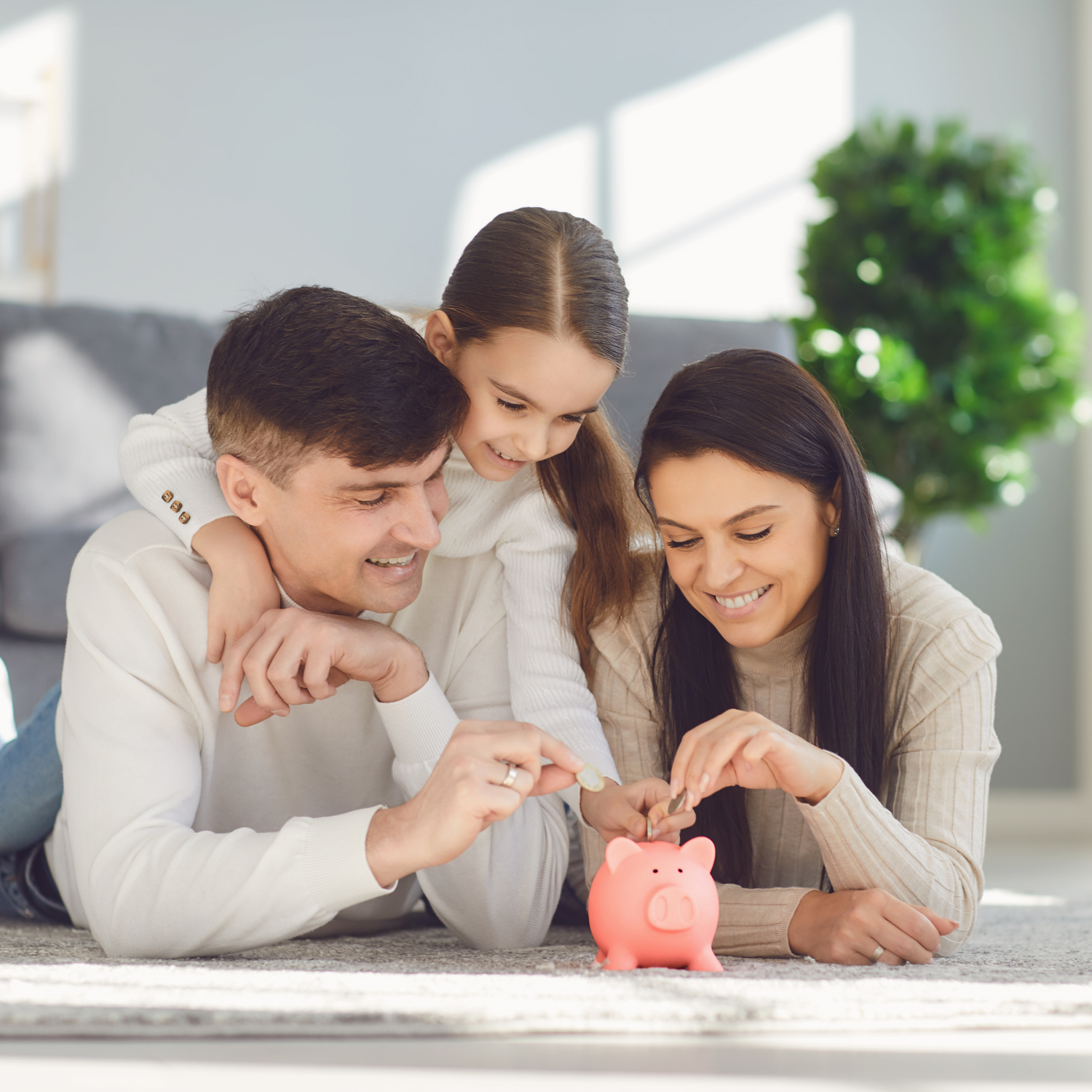 Parents and Little Daughter Saving Money in Their Home