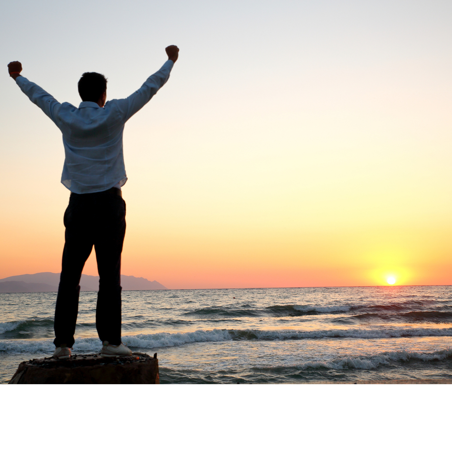 Person Celebrating with Hands Up in Front of Sunset at a Beach